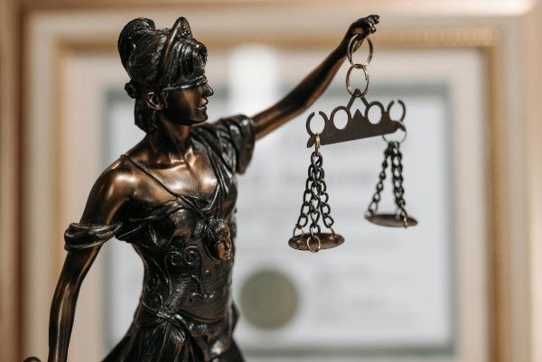 Figur von Justitia auf einem Schreibtisch eines Strafverteidigers